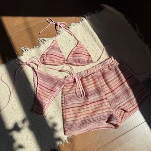 Detail der Textur des rosa gestreiften Strick-Bikinis mit passenden Strandshorts