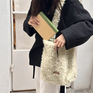 Detail of soft cream faux fur tote bag showing plush texture and brown leather logo tag