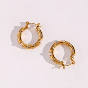 Detailed view of gold hoop earrings featuring alternating pearls and clear crystals