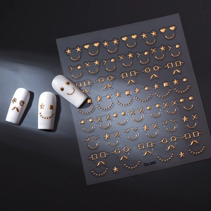 Macro detail of gold foil nail stickers Co-340 with smiling faces and star patterns