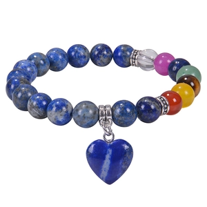 Macro detail of natural stone beaded bracelet with chakra beads and blue heart charm