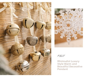Close-up of golden Christmas bells and white felt snowflake ornaments with elegant ribbons