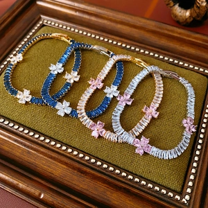 Detail of four floral zircon bracelets in multi-colors on a vintage green velvet display