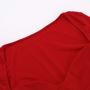 Gros plan détaillé de l'encolure et de la couture d'épaule de la robe en tricot rouge