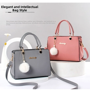 Detail of lychee textured crossbody bag with metal handle and plush ball charm