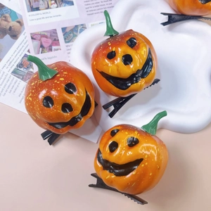 Three orange pumpkin hair clips with black smiling faces for Halloween parties