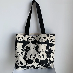 Detailed view of canvas tote bag featuring cute panda prints and durable black nylon straps