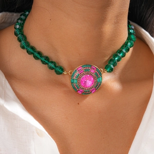 Collier vintage en perles de cristal vert avec pendentif rond en strass porté par un mannequin