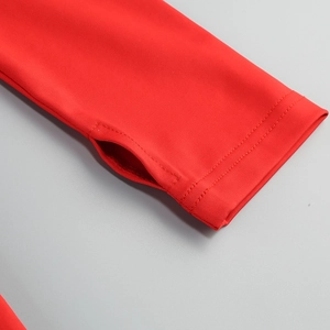 Detailed close-up of red mesh dress sleeve with functional thumbhole and stitching