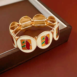 Detail view of vintage enamel geometric bracelet with gold alloy frame on wooden stand
