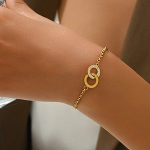 Close-up of a gold-plated interlocking ring bracelet with sparkling pave crystals on wrist