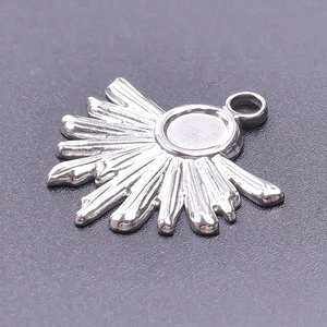 Detailed close-up of a silver sunburst pendant made from durable stainless steel material