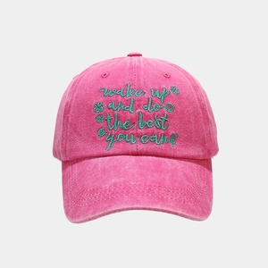 Detail of rose pink washed baseball cap with green embroidery and vintage texture