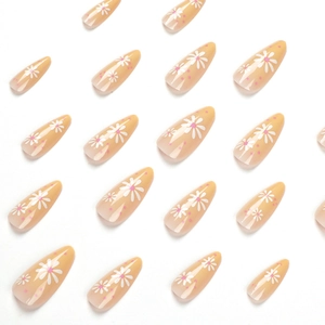 Pink polka dot and daisy floral press-on nails in long almond shape on white background