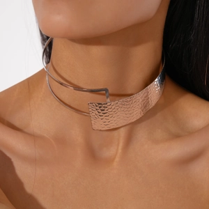 Detailed view of shiny silver metallic choker with hammered texture on female neck