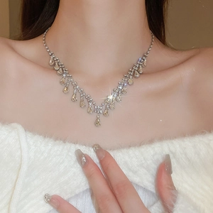 Detail of luxury teardrop necklace with silver tassels and champagne rhinestones on model