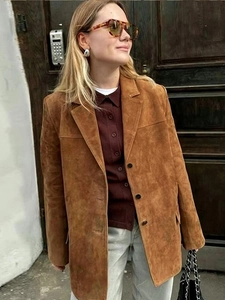 Gros plan de la veste en daim marron montrant le col à revers et la texture douce