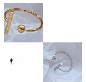 Macro detail of T-shape titanium steel open rings with 18k gold plating and ball end