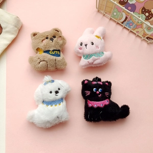 Detail of four cute plush animal brooches featuring a bear, bunny, dog and cat figurines