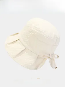 Detail of cream bow bucket hat featuring textured ripple fabric and stylish sun protection