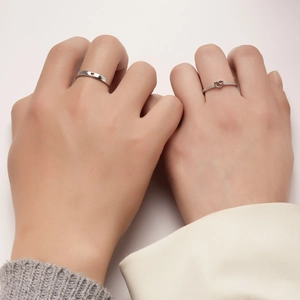 Detail of silver couple rings set with heart-shaped cutout and pavé cubic zirconia