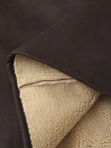 Detailed macro view of deep brown suede fabric with soft beige sherpa lining texture