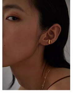 Close-up of minimalist double-layered C-shaped gold ear cuff on female model