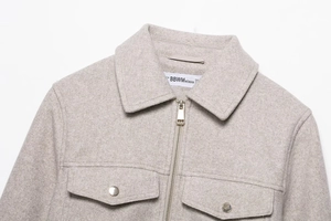 Detailed macro of a soft grey textured zip-up bomber jacket featuring metal zipper and pockets