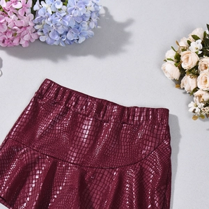 Detailed macro view of burgundy faux leather skirt with crocodile texture and elastic waist