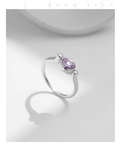 Détail macro d'une bague en argent S925 avec gemme violette ovale et diamants latéraux