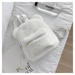 Detailed close-up of a white plush backpack with cute bear ear design and zipper pocket
