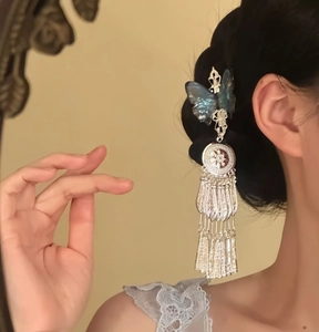 Detailed shot of a Chinese style blue butterfly hair clip with elegant silver tassels