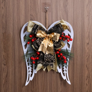 Detail of Christmas angel wing wreath with leopard bow and berries on wood wall