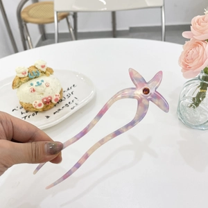 Détail d'épingle à cheveux étoile de mer en acétate marbré rose avec strass brillant