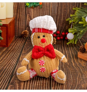 Close-up of plush gingerbread man with corduroy texture and chef hat on wooden background