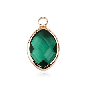 Close-up of emerald green marquise cut glass pendant with gold plated metal border