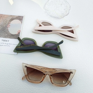 Flat lay of cat-eye anti-blue light glasses in beige, olive green and translucent tea