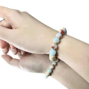 Minimalist beaded bracelet featuring light blue and reddish-brown natural stones on wrist