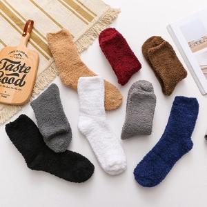 Flat lay of seven pairs of thick coral fleece socks in assorted solid colors on a cozy table