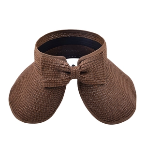 Brown woven foldable sun visor hat with a large decorative bow on a white background