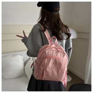 Detail of pink nylon backpack with floral embroidery and adjustable straps for women