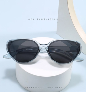 Close-up of stylish grey cat-eye sunglasses with UV protection on a clean display stand