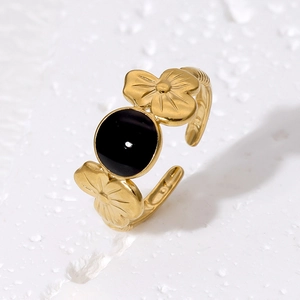 Detailed view of adjustable gold-finished stainless steel ring with black flower inlays