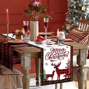Christmas table runner with reindeer motifs and Merry Christmas text on wooden table