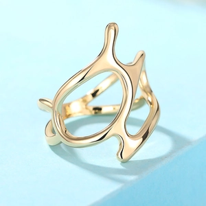 Macro detail of golden futuristic asymmetric hollow multi-layer ring on blue platform
