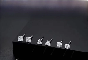 Macro shot of geometric S999 sterling silver stud earrings with clear zircon stones