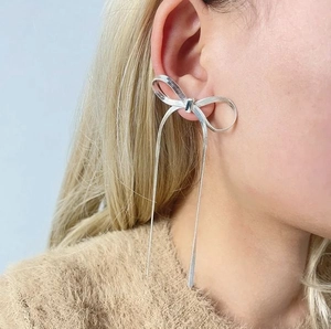 Elegant 18k silver bow stud earrings with long tassel detail worn by a model