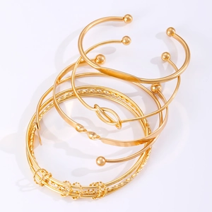 Detailweergave van een 6-delige gouden armbandset met geknoopte metalen ontwerpen
