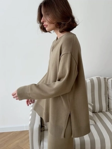 Détail du cardigan en maille kaki avec fente latérale et texture de tissu drapé haut de gamme