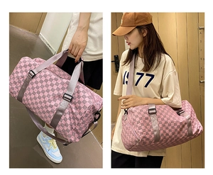 Detail view of a large capacity checkered travel bag worn by a model in an elevator